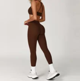 Person wearing a brown sports bra and leggings set on a white background