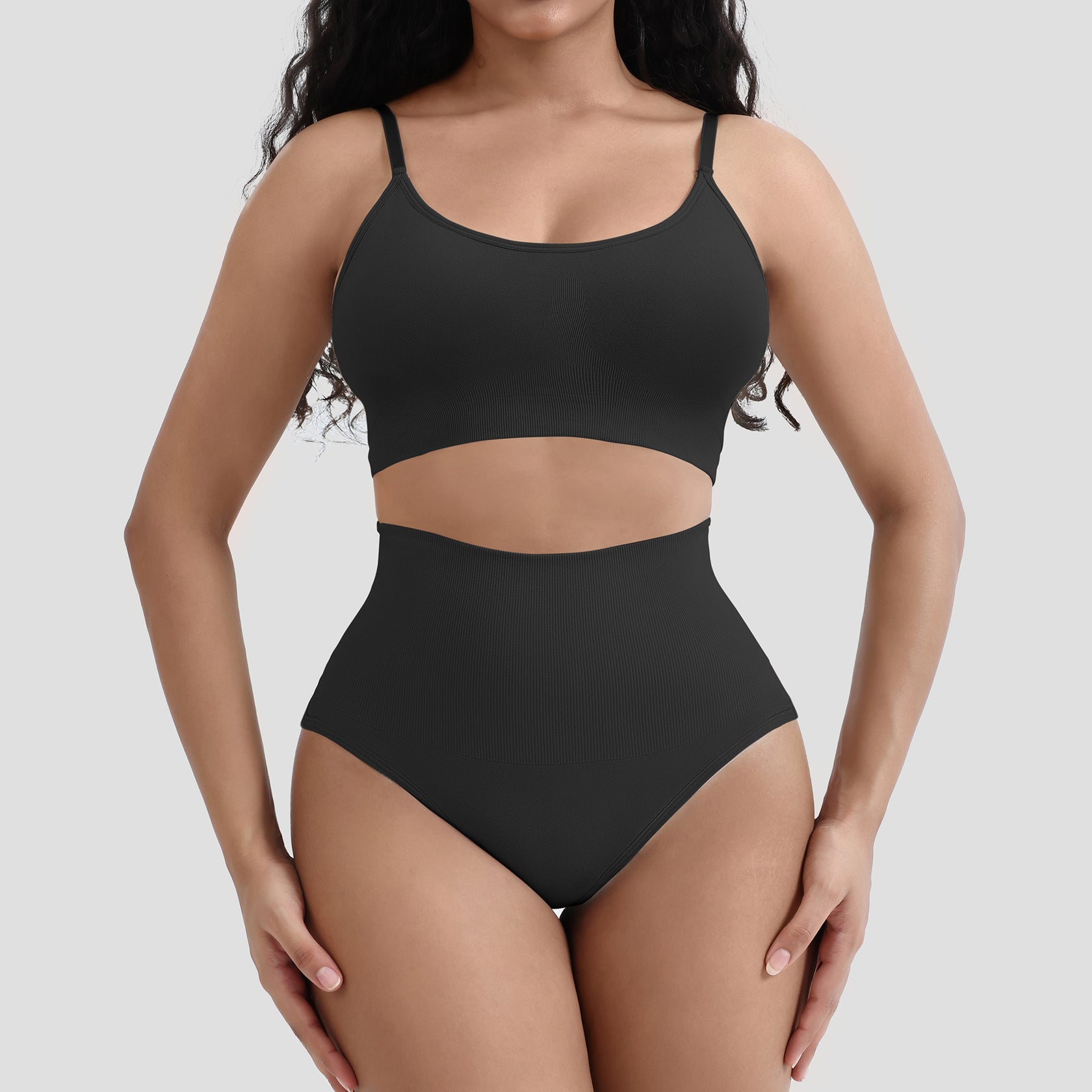 Black swimsuit worn by a model on a plain background